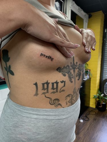 Pretty Script Underside-Boob Tattoo by Paul Ashcroft